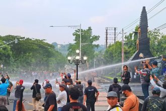 Polisi menyemprotkan water cannon ke arah massa aksi May Day di Jalan Pahlawan Semarang, Kamis (1/5/2025).