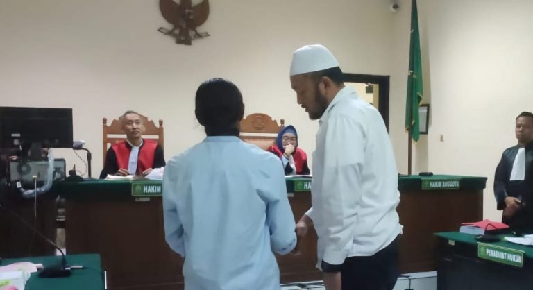 Aipda Robig (berprci), polisi penembak siswa, menyalami ayah korban penembakan, dalam sidang di PN Semarang, Selasa (6/5/2025).