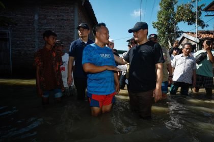 Gubernur Jateng Ahmad Luthfi (kanan depan) berbincang dengan warga saat meninjau banjir rob di Sayung, Demak, Minggu (25/5/2025).