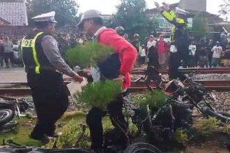 Petugas saat mengevakuasi korban dan kendaraan pasca kecelakaan maut di Jalur Perlintasan Langsung Kereta Api di wilayah Desa/ Kecamatan Barat, Kabupaten Magetan, Senin (19/5/2025) siang.