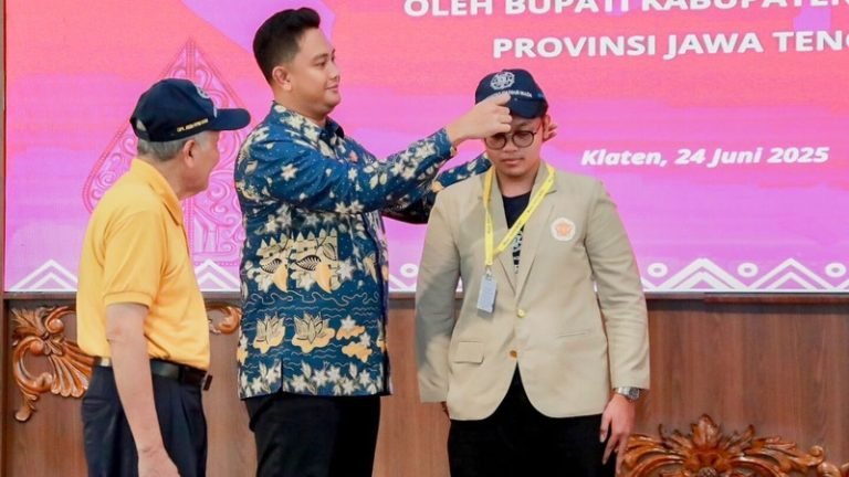 Bupati Klaten Hamenang Wajar Ismoyo mengenakan topi sebagai tanda penerimaan kepada mahasiswa KKN-PPM UGM.