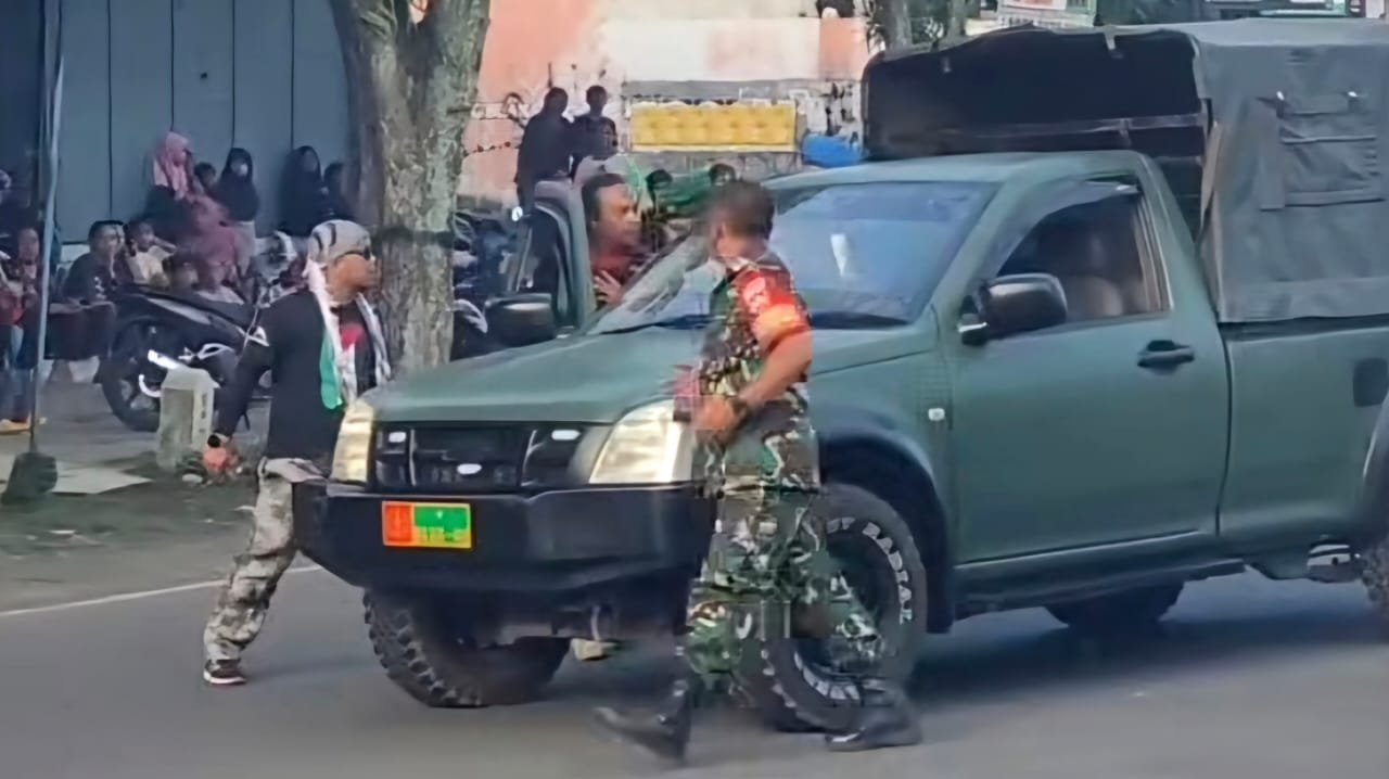 Anggota ormas GPK (kiri) tampak emosi kepada anggota TNI pengemudi mobil OZ. (tangkapan layar dari media sosial)