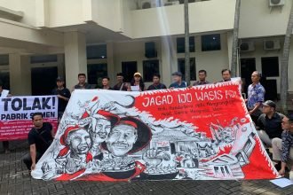 Warga Wonogori membentangkan spanduk di depan kantor DLHK Jateng, spanduk berisi kritik pendirian pabrik semen. (dokumentasi warga)