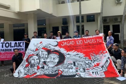 Warga Wonogori membentangkan spanduk di depan kantor DLHK Jateng, spanduk berisi kritik pendirian pabrik semen. (dokumentasi warga)