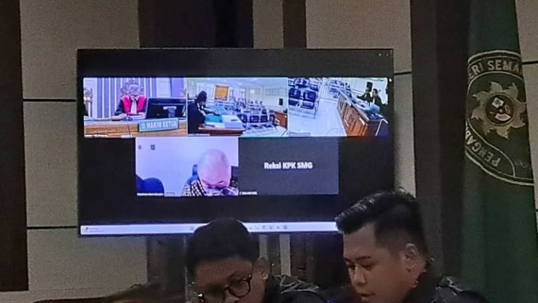 Terdakwa Rachmat Utama Djangkar (kepala pelontos di layar monitor) terlihat tertuntuk menyeka air mata saat membaca nota pembelaan sidang yang berpusat di Pengadilan Tipikor Semarang, Rabu (11/6/2025). (bai)