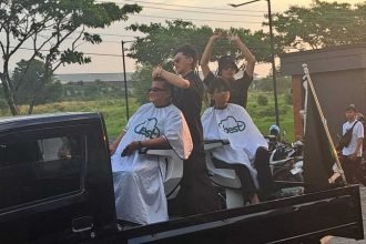 Rangkaian Grand Opening Best Pangkas Rambut diwarnai dengan praktik cukur rambut di atas mobil yang sedang konvoi, Minggu (13/7/2025). (bae)