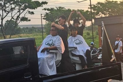 Rangkaian Grand Opening Best Pangkas Rambut diwarnai dengan praktik cukur rambut di atas mobil yang sedang konvoi, Minggu (13/7/2025). (bae)