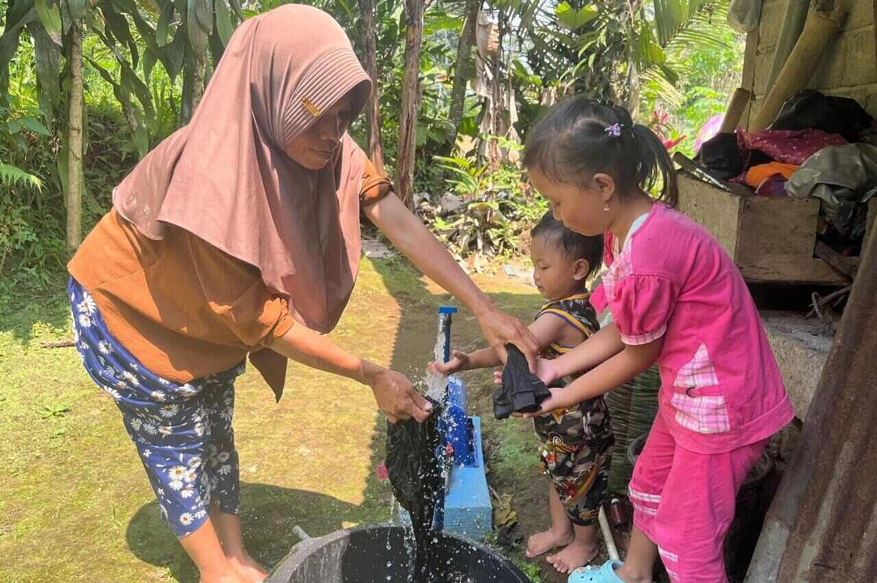 Warga Desa Talunombo Wonosobo mencuci bersama kedua anaknya menggunakan air SPAM. Setelah bertahun-tahun hidup dalam kesulitan air bersih, warga Desa Talunombo, Kecamatan Sapuran, Kabupaten Wonosobo, kini bisa tersenyum lega. Semua berkat bantuan Sistem Penyediaan Air Minum (SPAM) dari Pemerintah Provinsi Jawa Tengah . Foto: dok/humas
