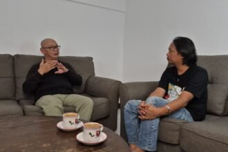 Koh Aming (kepala pelontos) sedang ngobrol bareng Host Lek Slam di Podcast Kerjo Aneh-Aneh yang tayang di kanal Bacaajadotco. (wsn)