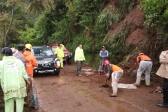 Petugas membersihkan material longsor di jalur Dieng-Wonosobo, saat Natal 2025.