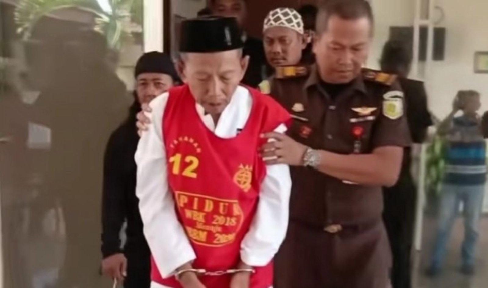 Kakek Masir dengan tangan diborgol, digiring jaksa menuju penjara.
