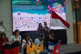 Bendera merah putih berkibar dalam parade negara-negara peserta IWA Charity Bazaar di Bucharest, Rumania (7/12).