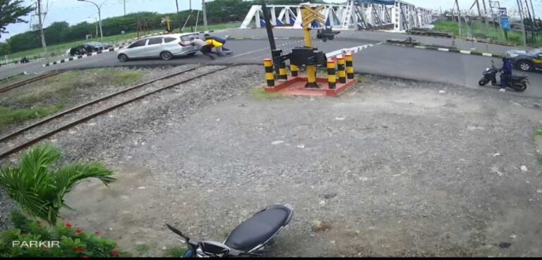 Kabid Humas Polda Jateng Kombes Artanto bersama 2 orang lain saat mendorong mobil mogok di lintasan KA Madukoro Kota Semarang, Selasa (13/1/2026) siang sesaat sebelum KA melintas. Foto: IST