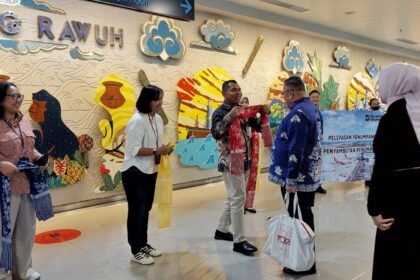 Pihak Bandara Ahmad Yani mengalungkan selendang simbolis untuk penumpang pertama tahun 2026.