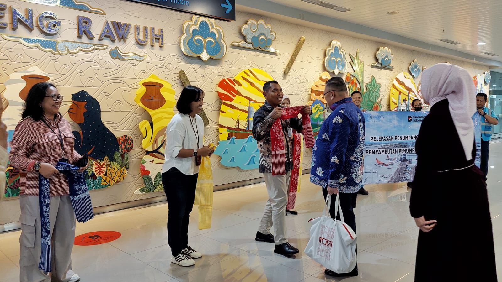 Pihak Bandara Ahmad Yani mengalungkan selendang simbolis untuk penumpang pertama tahun 2026.