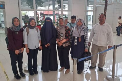 Maryam, eks-napiter (bercadar) berfoto bersama petugas, sebelum dideportasi ke Malaysia melalui Bandara Ahmad Yani Semarang, Sabtu (3/1/2026).