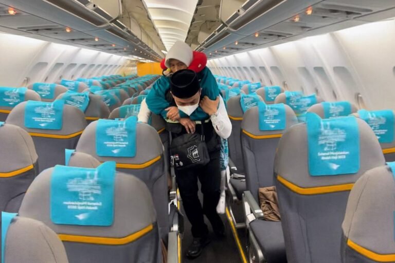 Ilustrasi petugas haji daerah membantu jemaah haji yang membutuhkan pertolongan.