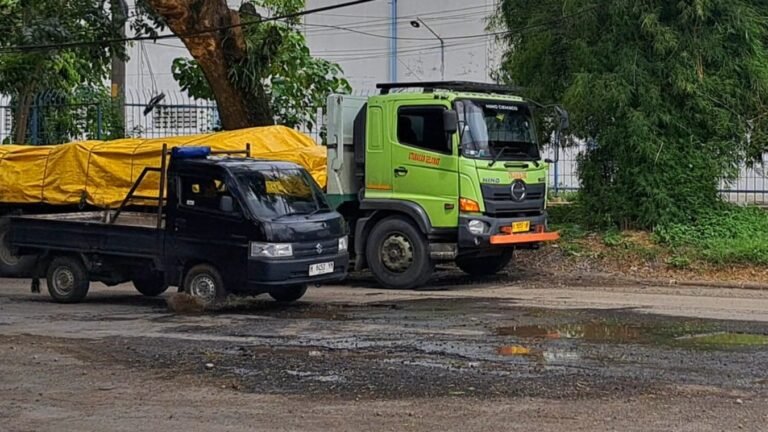 Mobil pickup roda depannya kejeblos lubang jalan di Kawasan Industri Candi Semarang, Minggu (25/1/2026). (bae)