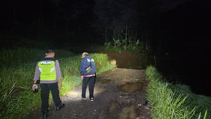 Petugas ngecek kondisi tanah longsor yang memutus akses jalan antardesa di Kecamatan Gemawang, Kabupaten Temanggung, Jumat (2/1/2026) malam.