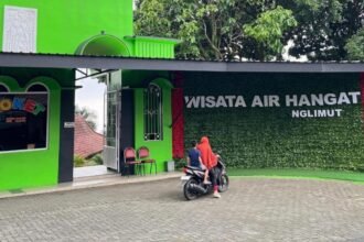 Pengendara motor berhenti di depan pintu masuk wisata air hangat Nglimut, Rabu (14/22026). (dul)