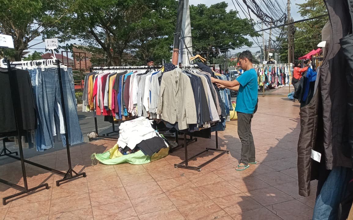 Pengunjung sedang memilih baju bekas di lapak thrifting depan Sam Po Kong, Semarang.
