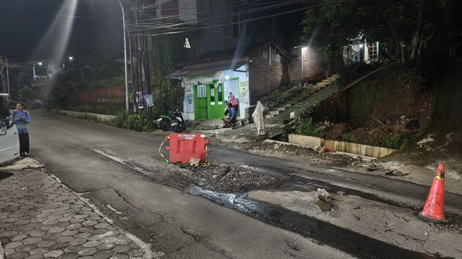 Jalan yang hancur tepat di tengah2 jalan dan di beri traffic cone dan pembatas plastik. Jum'at (27/3/2026). (dul)