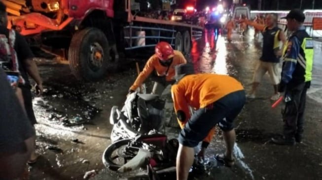 Ilustrasi petugas mengevakuasi bangkai kendaraan korban kecelakaan beruntun.