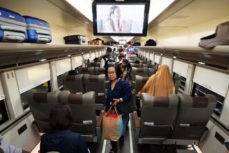 Ilustrasi penumpang kereta api mencari tempat duduk sesuai yang tertera di tiket miliknya.