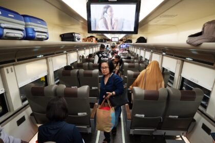 Ilustrasi penumpang kereta api mencari tempat duduk sesuai yang tertera di tiket miliknya.
