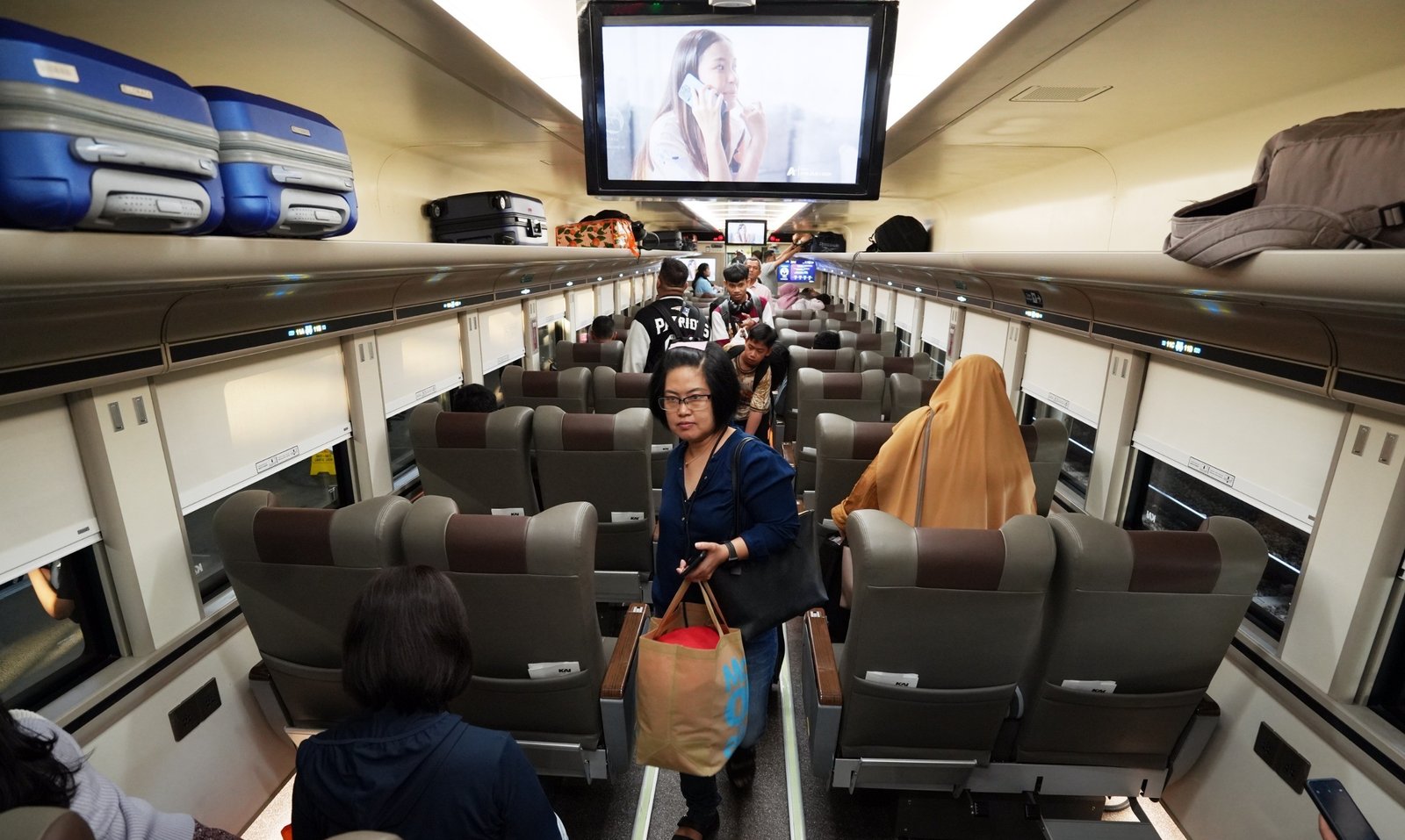 Ilustrasi penumpang kereta api mencari tempat duduk sesuai yang tertera di tiket miliknya.