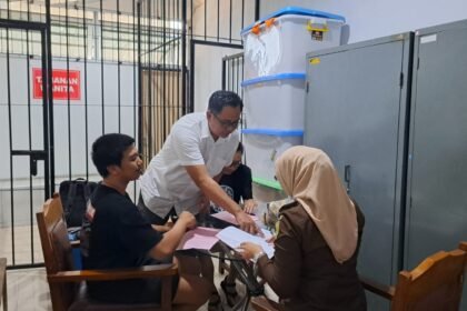 TERSANGKA CENGENGESAN -- Dua tersangka kasus peredaran sabu-sabu (berkaus hitam) masih bisa senyum-senyum saat diserahkan penyidik polisi ke jaksa penuntut umum, Rabu (13/5/2026). (bae)