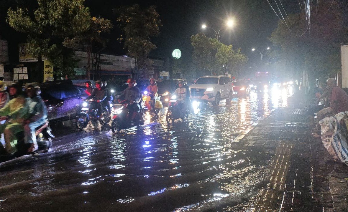 BANJIR - Pengendara melintasi genangan banjir di sekitar area pelaksanaan Semarang Night Carnival (SNC) 2026, yang akhirnya batal digelar, Sabtu (2/5/2026). (dul)