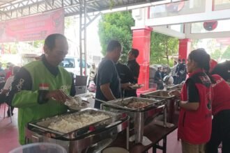 ANTUSIAS - Seorang driver ojol antusias mengambil menu makan di Dapur Marhaen, Kantor DPD PDIP Jateng, Minggu (10/5/2026). Seluruh menu makanan di Dapur Marhaen dimasak oleh kader partai dan relawan, mencerminkan tingginya gotong royong. (dul)