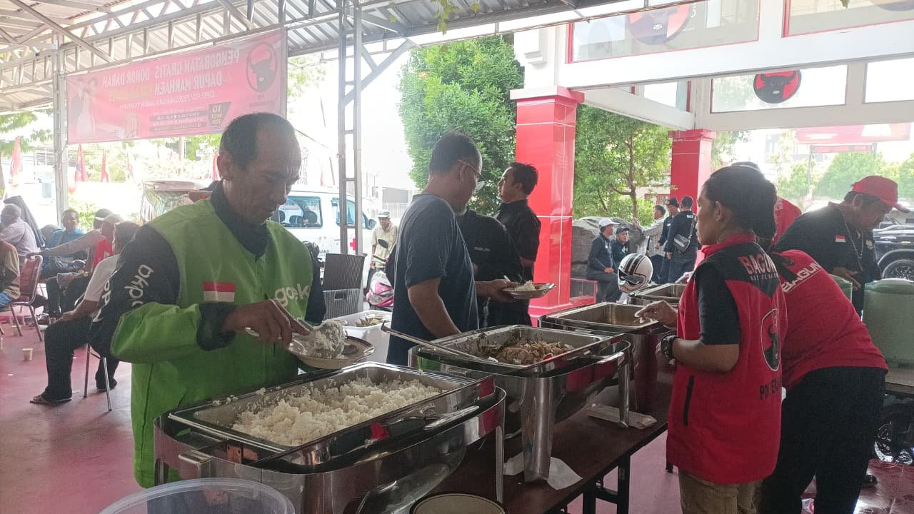 ANTUSIAS - Seorang driver ojol antusias mengambil menu makan di Dapur Marhaen, Kantor DPD PDIP Jateng, Minggu (10/5/2026). Seluruh menu makanan di Dapur Marhaen dimasak oleh kader partai dan relawan, mencerminkan tingginya gotong royong. (dul)