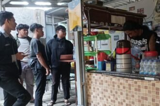 LAYANI PELANGGAN - Pegiat sosial-budaya sekaligus pemilik Angkringan West, Udin Larahan sedang melayani pelanggan warungnya. (dul)