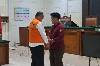 PAKAI ROMPI--Petugas kejaksaan memakaikan rompi tahanan AKPB Basuki usia sidang vonis. (bae)
