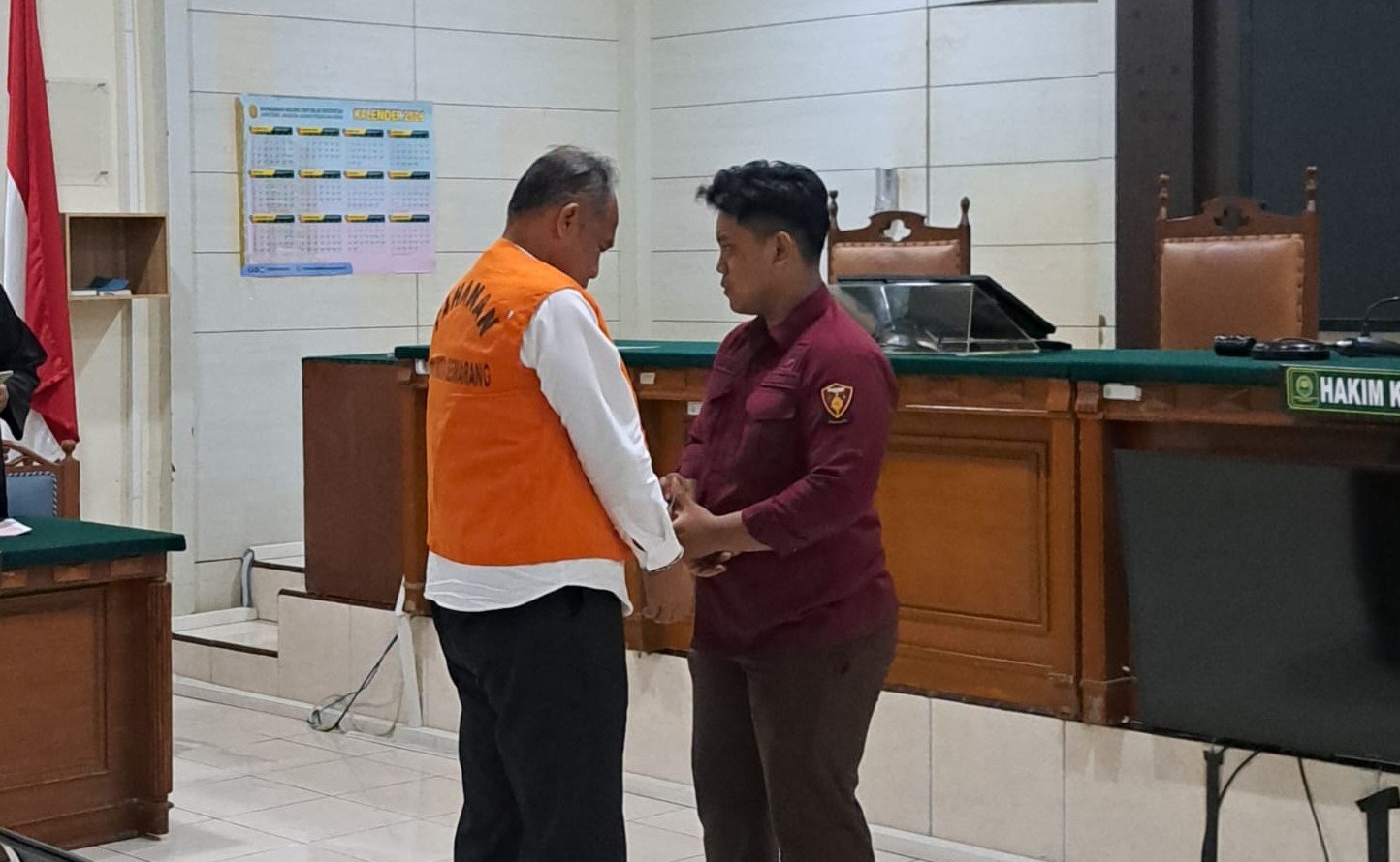 PAKAI ROMPI--Petugas kejaksaan memakaikan rompi tahanan AKPB Basuki usia sidang vonis. (bae)