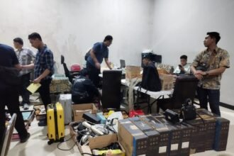 GELEDAH RUMAH--Petugas Imigrasi menggeledah rumah di kawasan perumahan elit Anjasmoro, Semarang, yang diduga jadi markas sindikat love scamming. (ist)