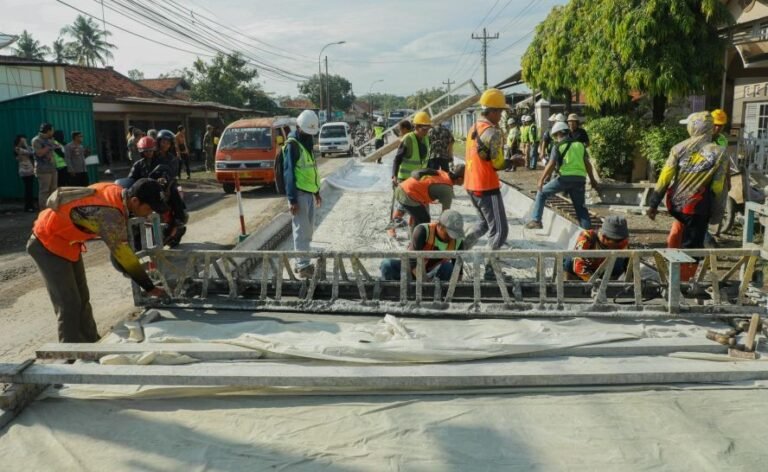PERBAIKAN JALAN - Sejumlah pekerja melakukan pengecoran jalan rusak.