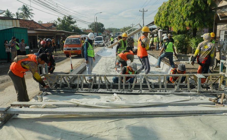PERBAIKAN JALAN - Sejumlah pekerja melakukan pengecoran jalan rusak.