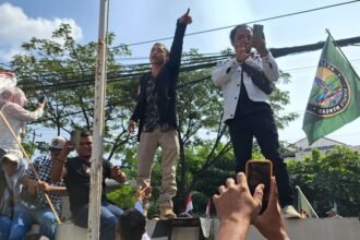 KAWAL SIDANG--Aktivis Pati, Ahmad Husein (berjas hitam), memanjat pagar meneriakkan dukungan terhadap Bupati Sudewo yang disidang di Pengadilan Tipikor Semarang, Senin (22/6/2206). (bae)