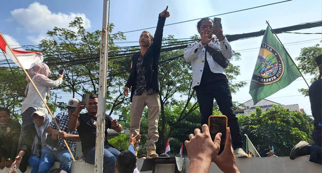 KAWAL SIDANG--Aktivis Pati, Ahmad Husein (berjas hitam), memanjat pagar meneriakkan dukungan terhadap Bupati Sudewo yang disidang di Pengadilan Tipikor Semarang, Senin (22/6/2206). (bae)