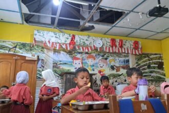 MAKAN MBG--Siswa SDN Pendrikan Lor 02 Semarang menyantap MBG di bawah ruang kelas yang atapnya ambrol, Selasa (28/7/2026). (bae)
