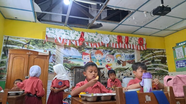 MAKAN MBG--Siswa SDN Pendrikan Lor 02 Semarang menyantap MBG di bawah ruang kelas yang atapnya ambrol, Selasa (28/7/2026). (bae)