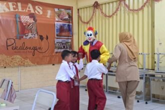 SAMBUT SISWA--Guru kelas dan badut menyambut 3 siswa baru SDN Purwoyoso 1 Semarang dalam rangkaian MPLS, Senin (13/7/2026). (bae)