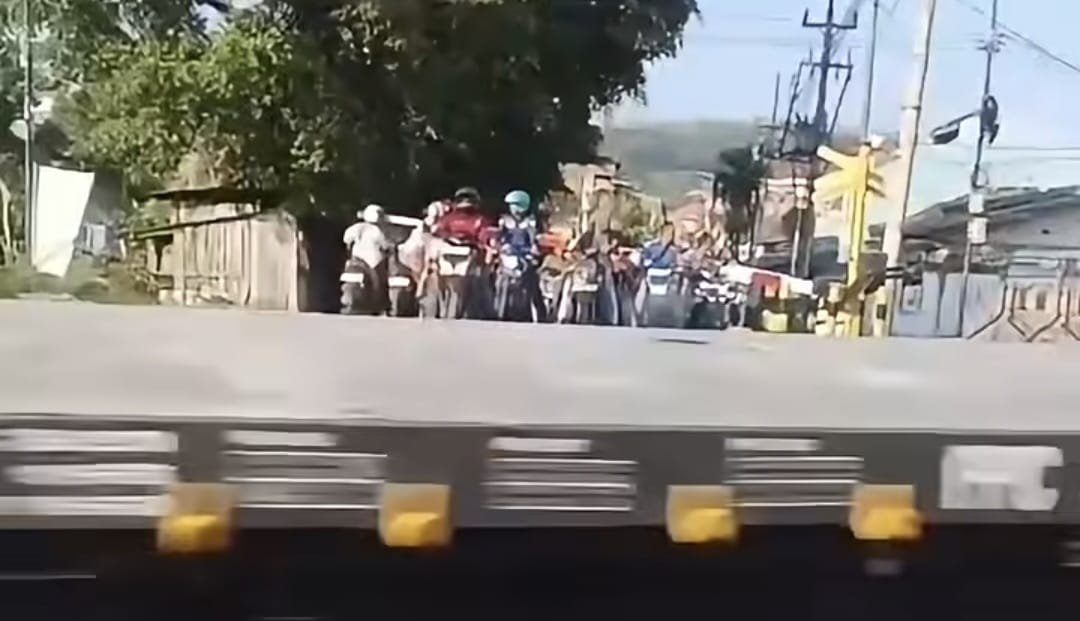 LINTASI REL--Sejumlah pengendara berhenti di dalam area palang saat kereta api sedang melintas di perlintasan Mangkang, Semarang. (ist)