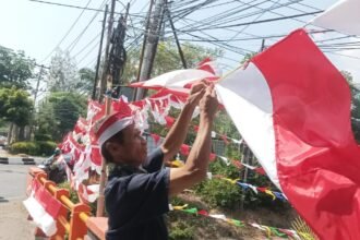TAK RAMAI LAGI - Pedagang bendera dan umbul-umbul sedang merapikan dagangan mereka, di pinggir jalan di Semarang. Pelapak bendera curhat, dagangan mereka kini sepi tak seramai dulu lagi. Kata mereka, lapak bendera pinggir jalan kalah saing sama pedagang online. (dul)