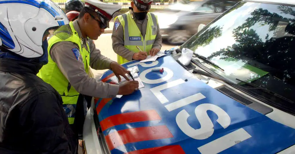 TILANG - Ilustrasi polisi lalu lintas (Polantas) melakukan tilang manual terhadap pengendara yang melanggar aturan lalu lintas.