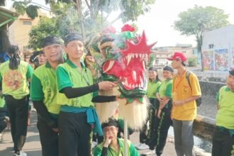 BARONGSAI - Sejumlah pemain barongsai mengenakan baju hijau, tengah memegang kepala barongsai dan memegang dupa, Jumat (25/9/2026). Mereka baru saja mengikuti atraksi untuk meramaikan gelaran Mooncake Festival di Kawasan Pecinan Semarang. (dul)