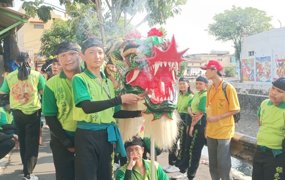 BARONGSAI - Sejumlah pemain barongsai mengenakan baju hijau, tengah memegang kepala barongsai dan memegang dupa, Jumat (25/9/2026). Mereka baru saja mengikuti atraksi untuk meramaikan gelaran Mooncake Festival di Kawasan Pecinan Semarang. (dul)